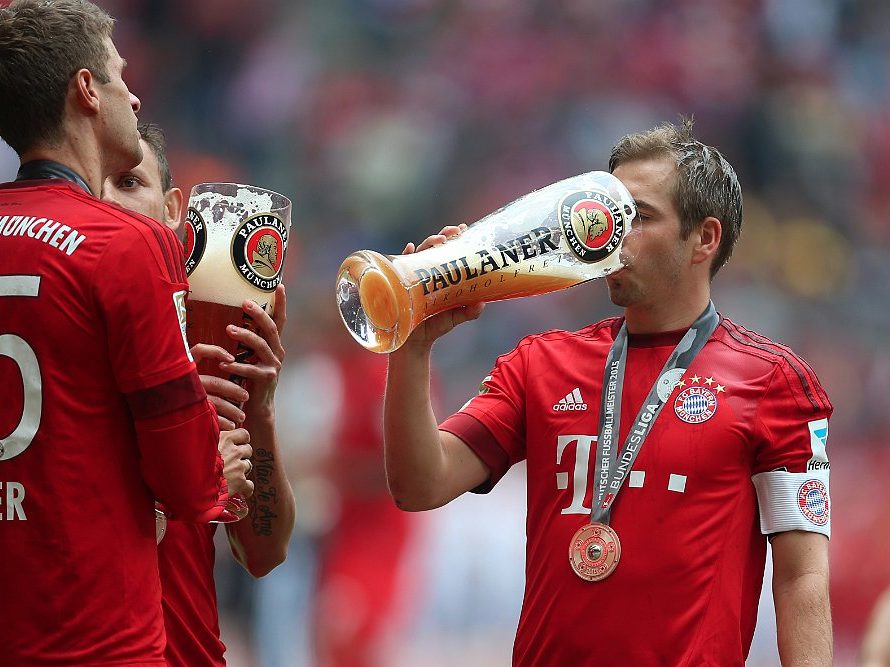 優勝祝いに特大ビールを飲むサッカー選手
